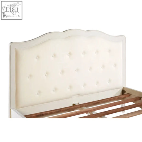 Cream-colored tufted headboard with scalloped top and white bayur wood frame for loire white kingsize bed