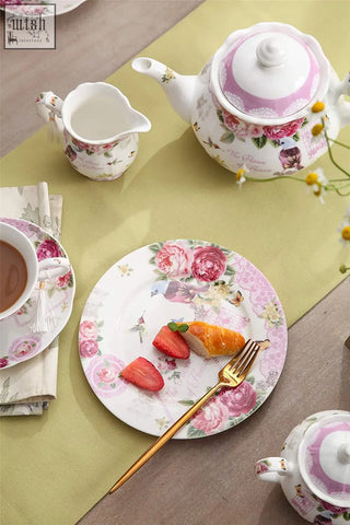 Pink and white floral-patterned ceramic teapot with matching lid in bird rose butterfly design from london boutique