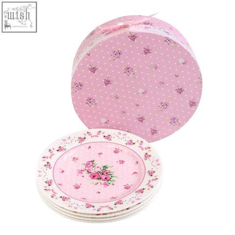 Stacked london boutique rose pink ceramic dessert plates with floral pattern in front of a matching polka dot gift box