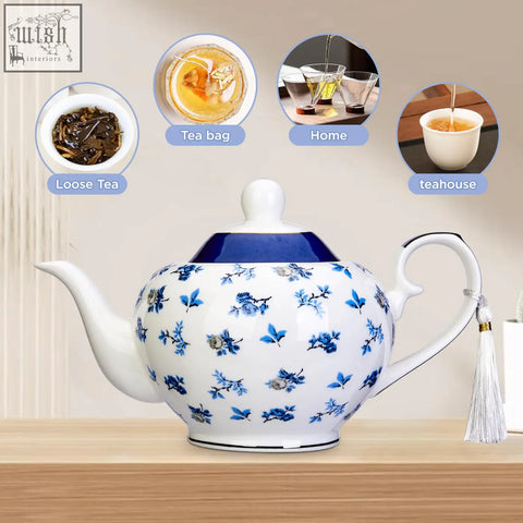 White ceramic london boutique teapot with blue floral patterns navy lid gold edge trim and easy grab handle for loose tea