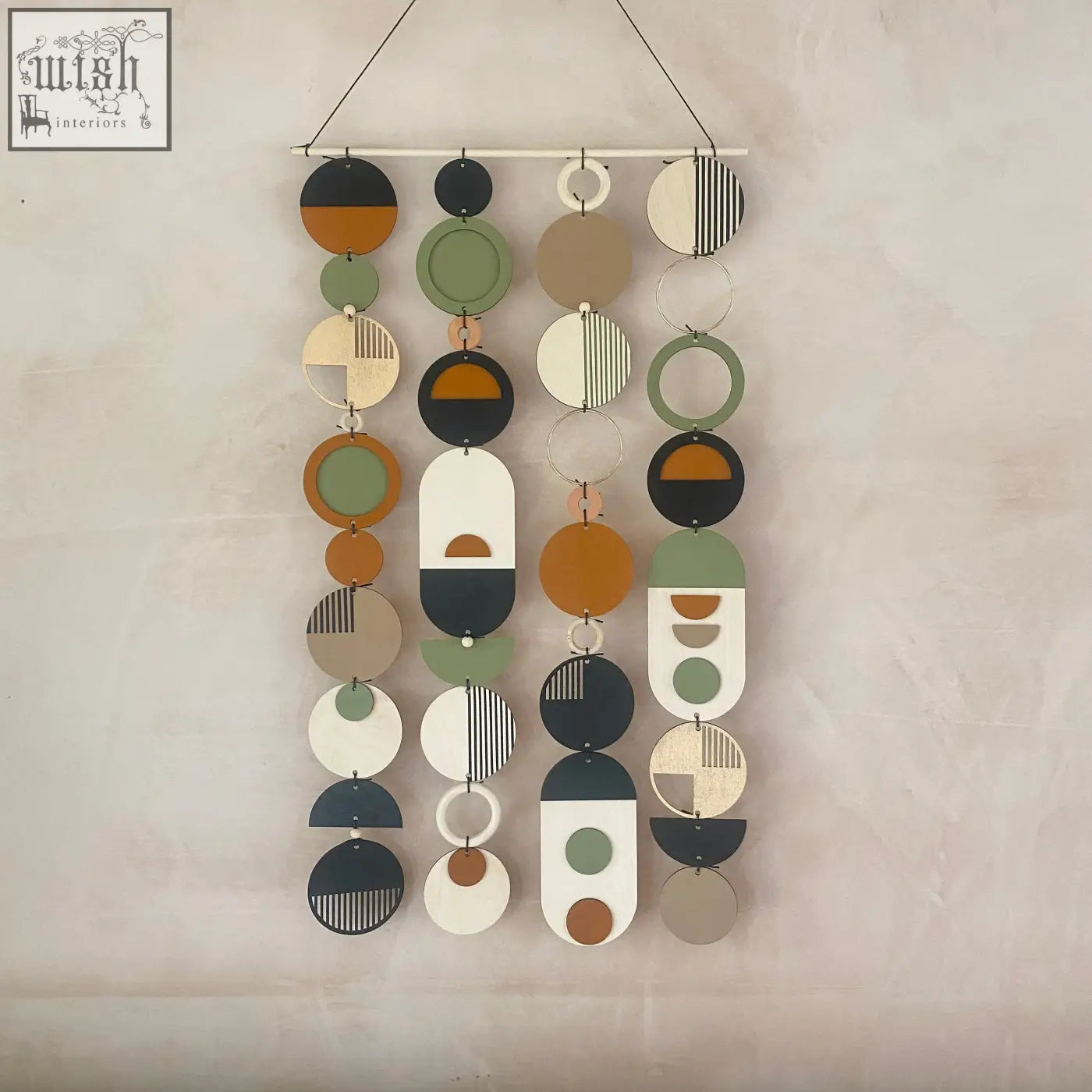 A modern hand painted engraved wood wall art with geometric circular discs in olive green terracotta black white and beige