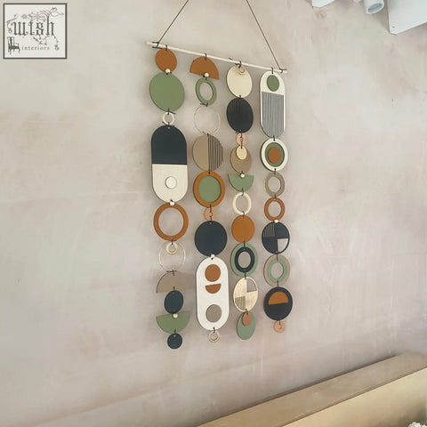 Longer wall art featuring hand painted engraved geometric shapes in olive green terracotta black and natural wood tones