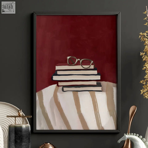 A framed abstract lounge room wall print with stacked books and silver glasses on burgundy background for room wall decor