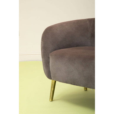 A plush taupe velvet round armchair with sleek gold-tone legs perfect for stylish living spaces