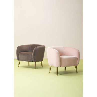 Two upholstered armchairs including a grey velvet round armchair and a pink velvet round armchair with gold legs