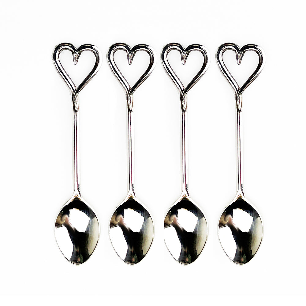 Set of four polished stainless steel love heart spoons with reflective surfaces perfect for gift box giving