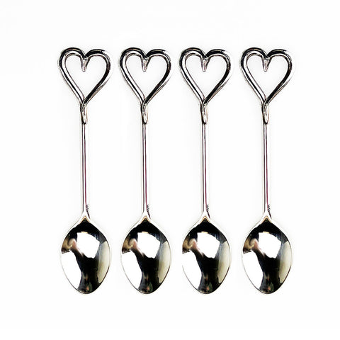 Set of four polished stainless steel love heart spoons with reflective surfaces perfect for gift box giving