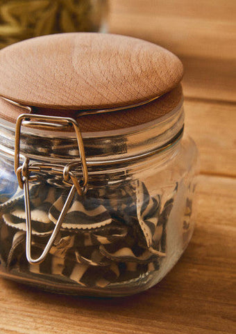Clear glass luca square 500ml jar with wooden lid and metal clasp holding dried black and white striped mushrooms