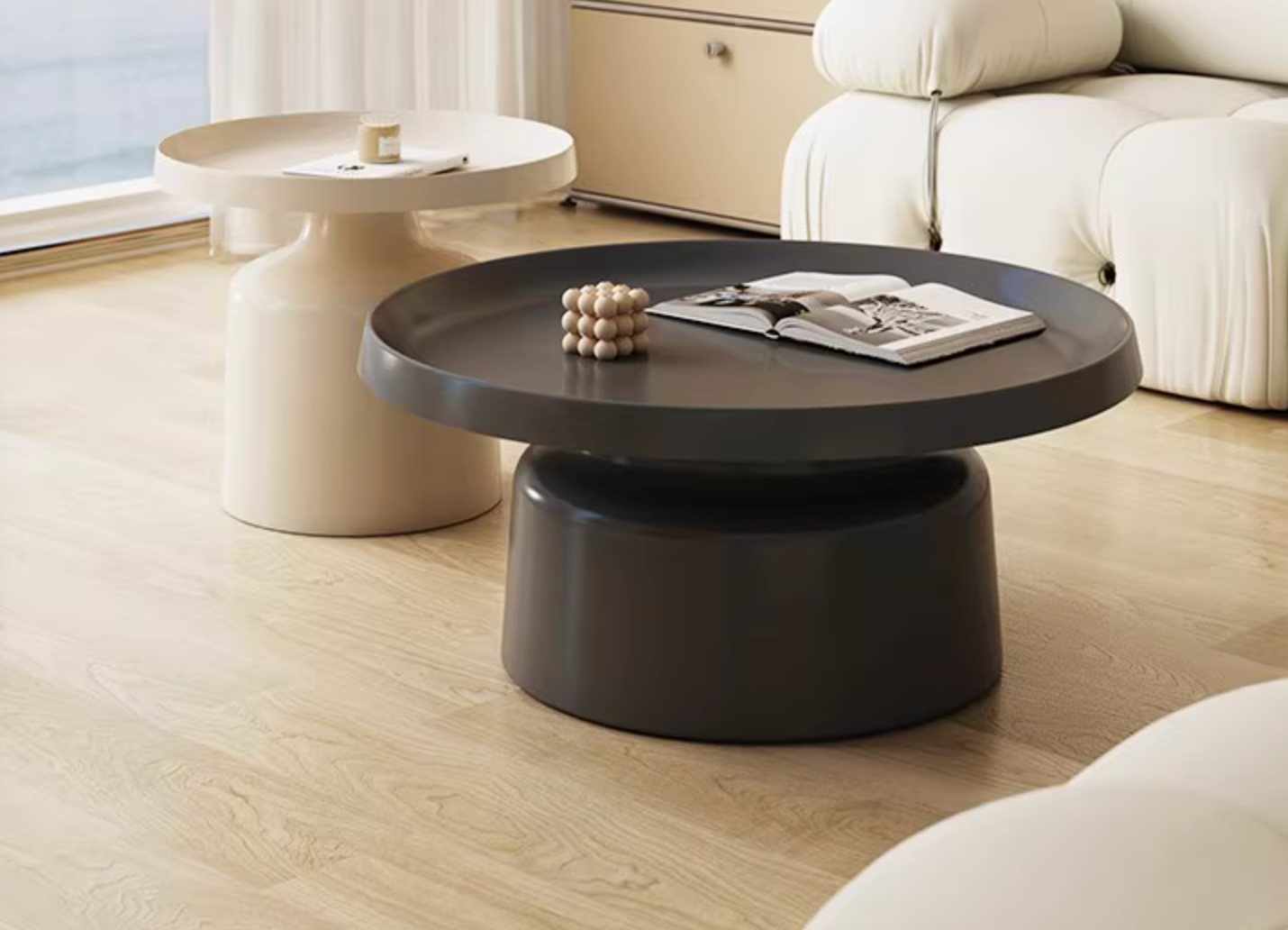 Dark gray lucas coffee table with sleek cylindrical base and smooth rounded top in modern coffee table set