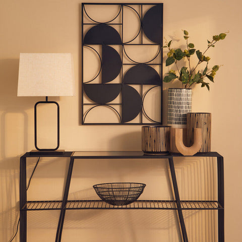 Black metal geometric wall art with circular cutouts on the lucas natural and black table lamp base