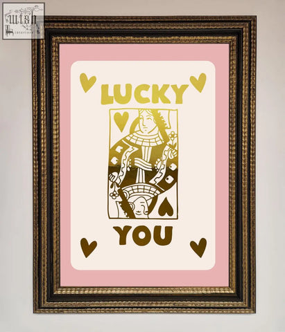 A framed lucky you foil print featuring a queen of hearts design with gold lettering on pink with quick shipping times