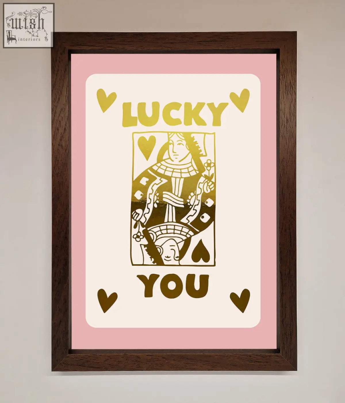 A lucky you foil print of a gold queen of spades playing card in cream with pink border in a dark wood frame with fast shipping times