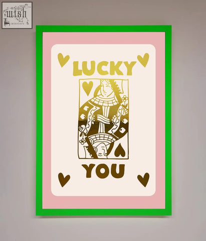 A lucky you foil print framed poster with gold stylized playing card on cream background with pink border and green frame perfect for fast shipping times