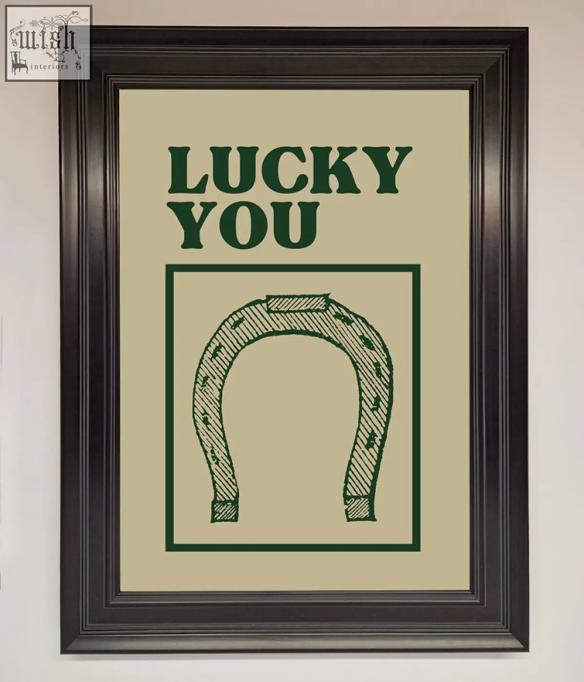 Framed wall art featuring a green horseshoe and lucky you text on beige background with frame choices for decor