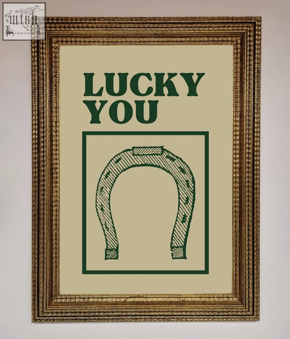 Framed wall art print with cream background featuring bold green lucky you text and a stylized green horseshoe design