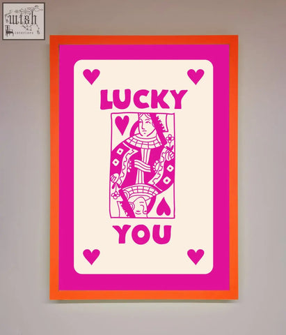 A hot pink framed poster featuring a vibrant pink and orange stylized playing card design with lucky you text