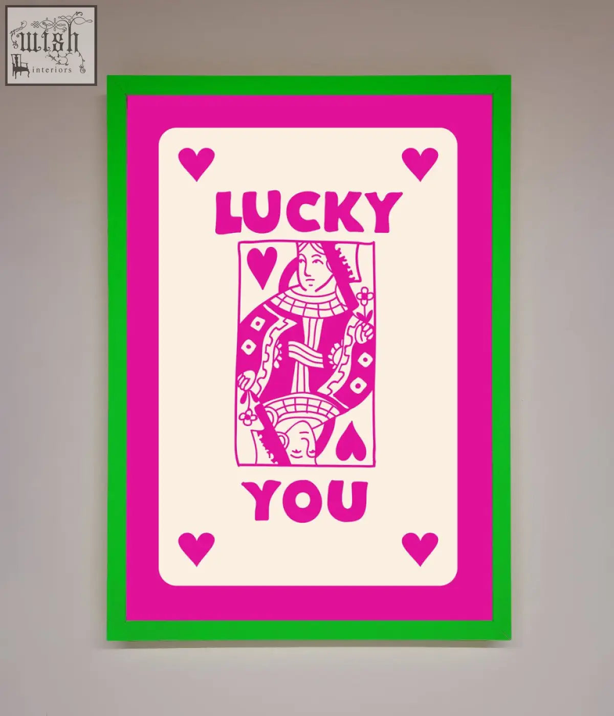 A hot pink framed poster featuring a vibrant pink and green stylized playing card design with lucky you text