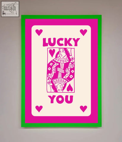 A hot pink framed poster featuring a vibrant pink and green stylized playing card design with lucky you text