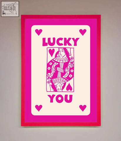 A hot pink framed pink framed poster featuring a stylized queen of hearts with lucky you in bold magenta letters