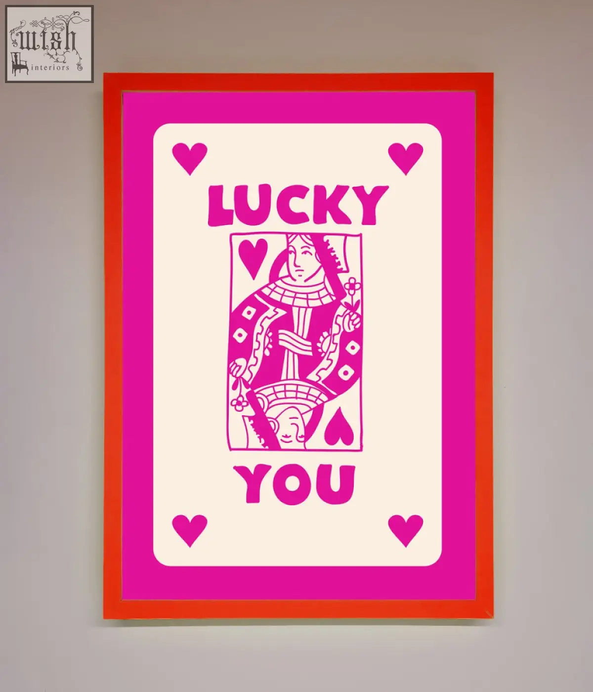 A vibrant hot pink framed poster with a pink framed stylized playing card design and lucky you in bold magenta letters
