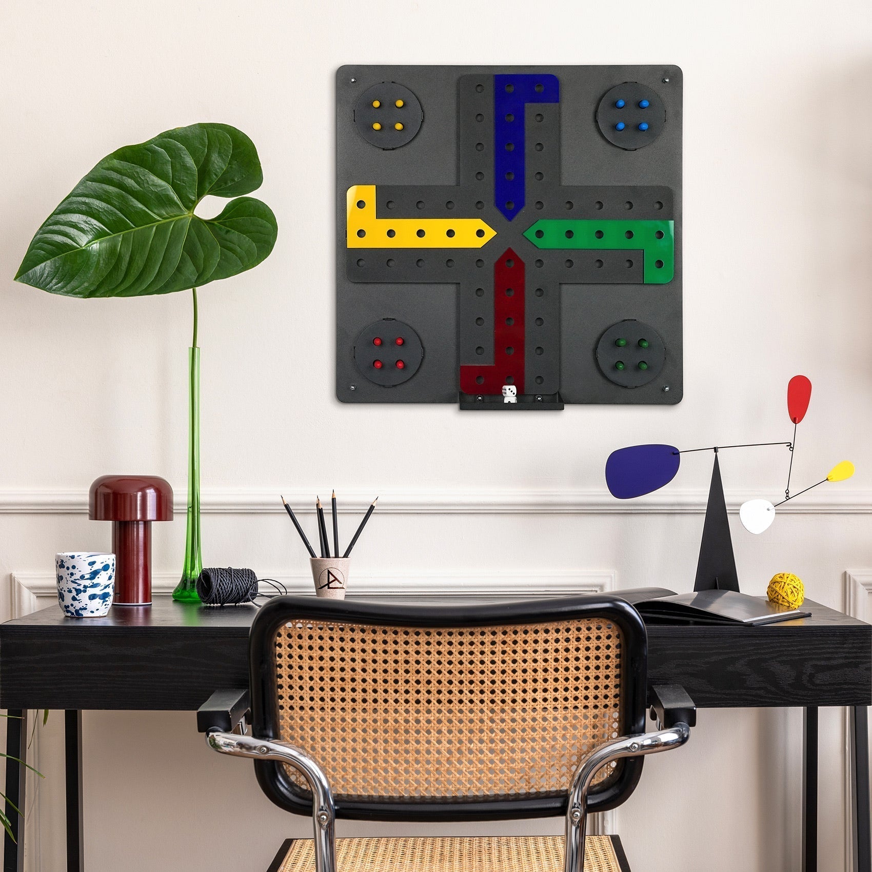 Black wall-mounted ludo wall game with colorful yellow green blue and red paths and easy hanging instructions