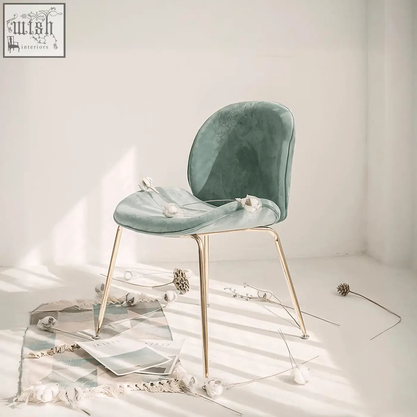 A sleek mint green velvet lule dining chair with slender painted steel gold legs perfect for dining rooms