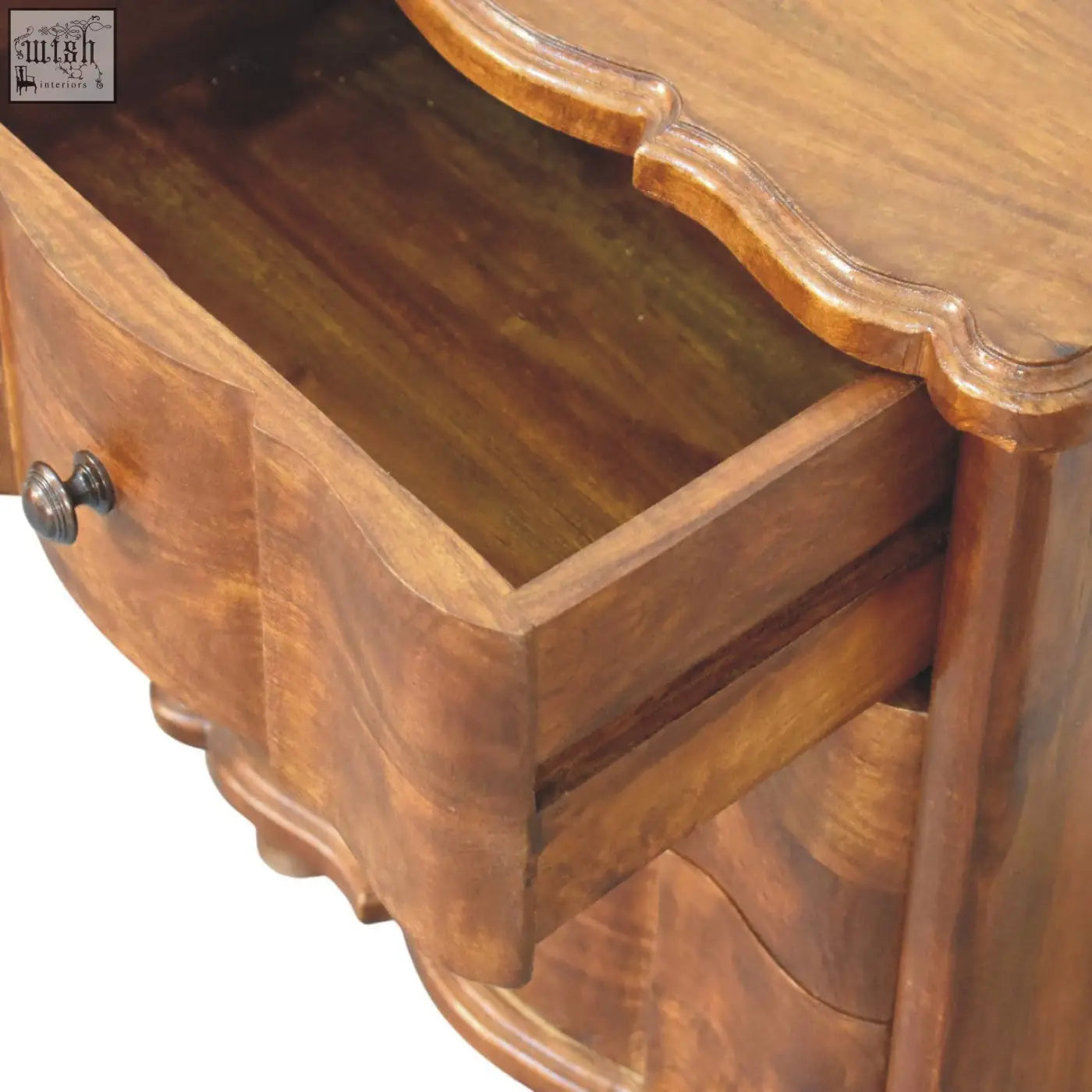 Antique-style wooden bedside table with warm brown finish and ornate curved edges in lume panel design