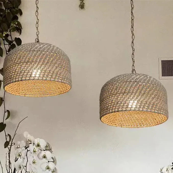 Two beige woven pendant lights with basket weave texture and warm interiors hanging on chains luna light design