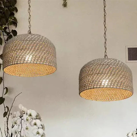 Two beige woven pendant lights with basket weave texture and warm interiors hanging on chains luna light design
