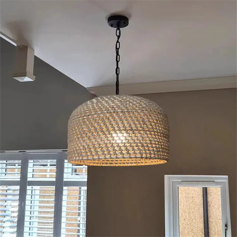 A woven beige rattan luna light pendant with a black metal chain and ceiling mount for stylish lighting