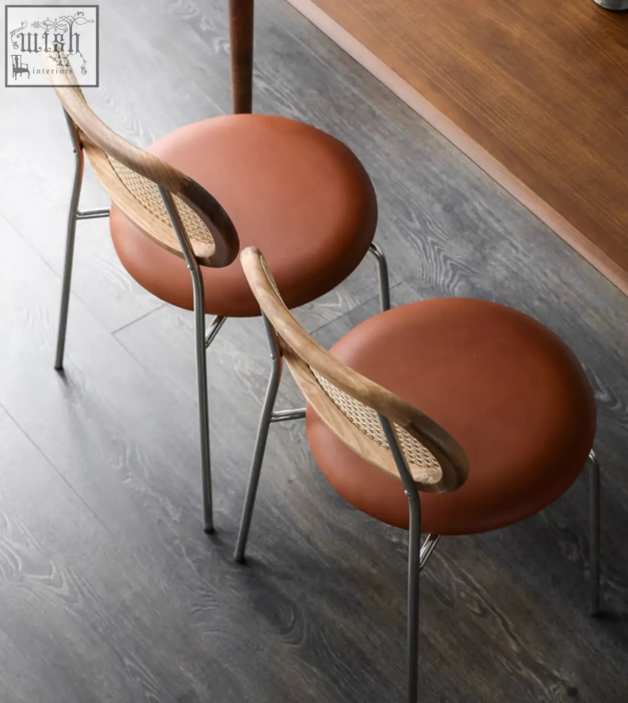 Brown leather cushioned luna rattan dining chair with woven cane back and slender metal legs in oak finish
