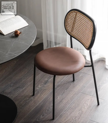 Modern luna rattan dining chair with black metal frame, woven cane backrest, and brown oak upholstered seat