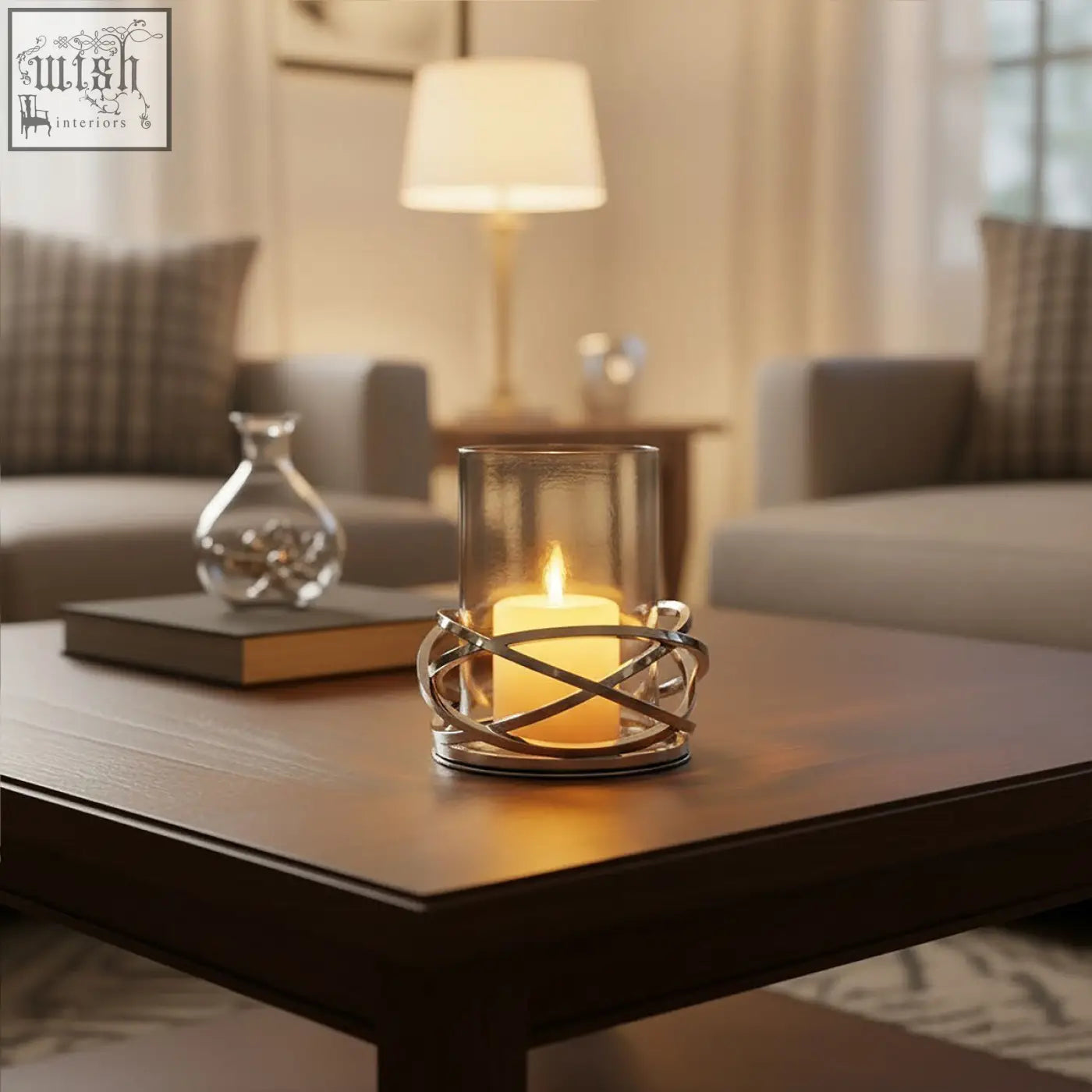 A sleek twist small silver candle holder with a clear glass cylinder and warm yellow pillar candle inside