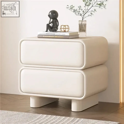 Cream-colored solid wood bedside table with rounded edges and two smooth drawers inspired by moroccan design