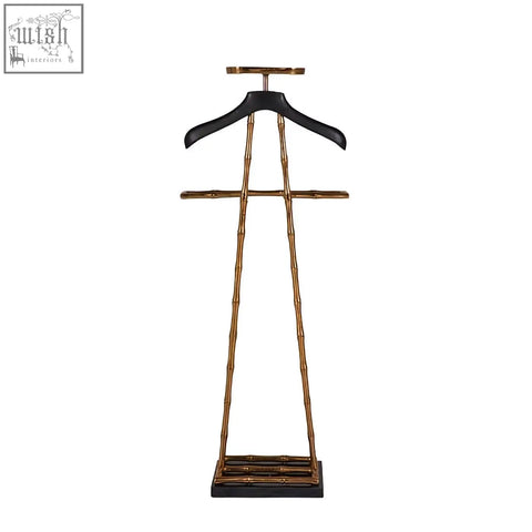 Gold-finished vintage brass bamboo-style garment stand with black wooden coat hanger and leather shoulder pad base