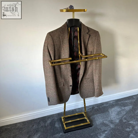 Brown houndstooth wool blazer with leather shoulder pad hanging on vintage brass gold bamboo-style coat hanger rack
