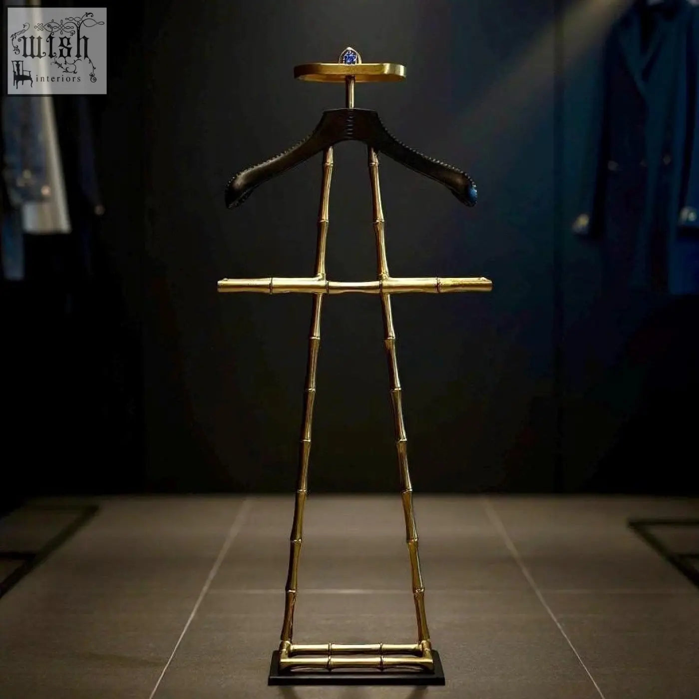 Luxury dressboy coat rack in vintage brass with a black leather shoulder pad and blue gemstone accent on top