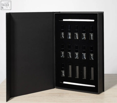 Black gift box with twelve clear glass perfume vials and black caps for lifestyle home fragrance discovery set