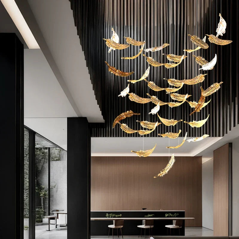 A luxury glass led chandelier with golden and white feather shaped glass panels hanging from the ceiling