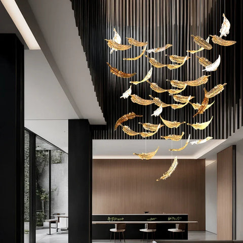 A luxury glass led chandelier with golden and white feather shaped glass panels hanging from the ceiling