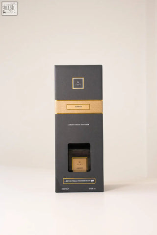 Luxury square diffuser in black and gold with amber-scented fragrance in a sleek rectangular reed diffuser box