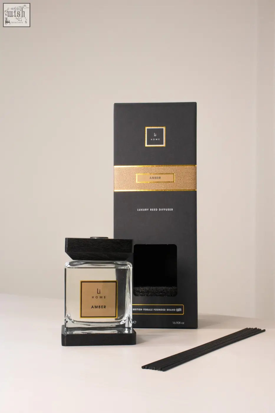 Luxury square diffuser amber with black and gold reed sticks in a clear glass bottle with amber-scented fragrance