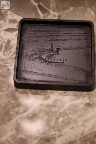 Black rectangular wood grain coaster with embossed lifestyle branding for luxury square diffuser amber