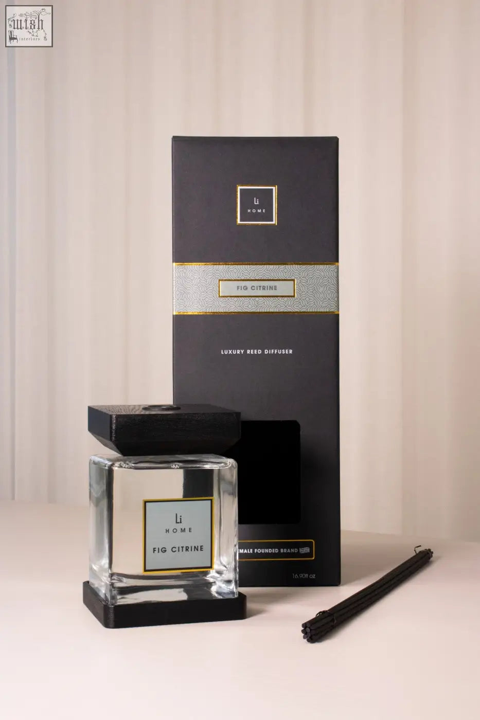 A sleek transparent glass fig citrine reed diffuser with a black square base and lid by li home