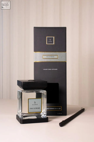 A sleek transparent glass fig citrine reed diffuser with a black square base and lid by li home