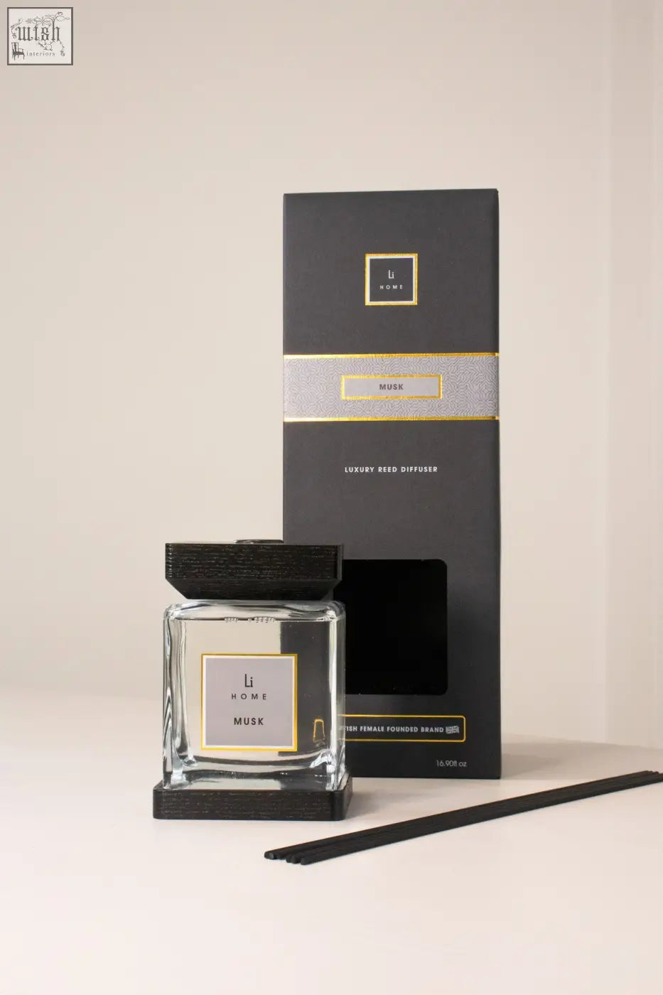 Black and gold musk luxury reed diffuser by li home with clear glass bottle and dark wood finish base and cap