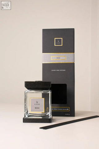 Black and gold musk luxury reed diffuser by li home with clear glass bottle and dark wood finish base and cap