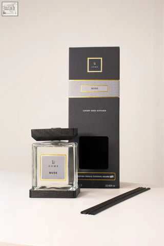 Luxury square glass reed diffuser with black wooden lid and base labeled li home musk with dark-colored reeds