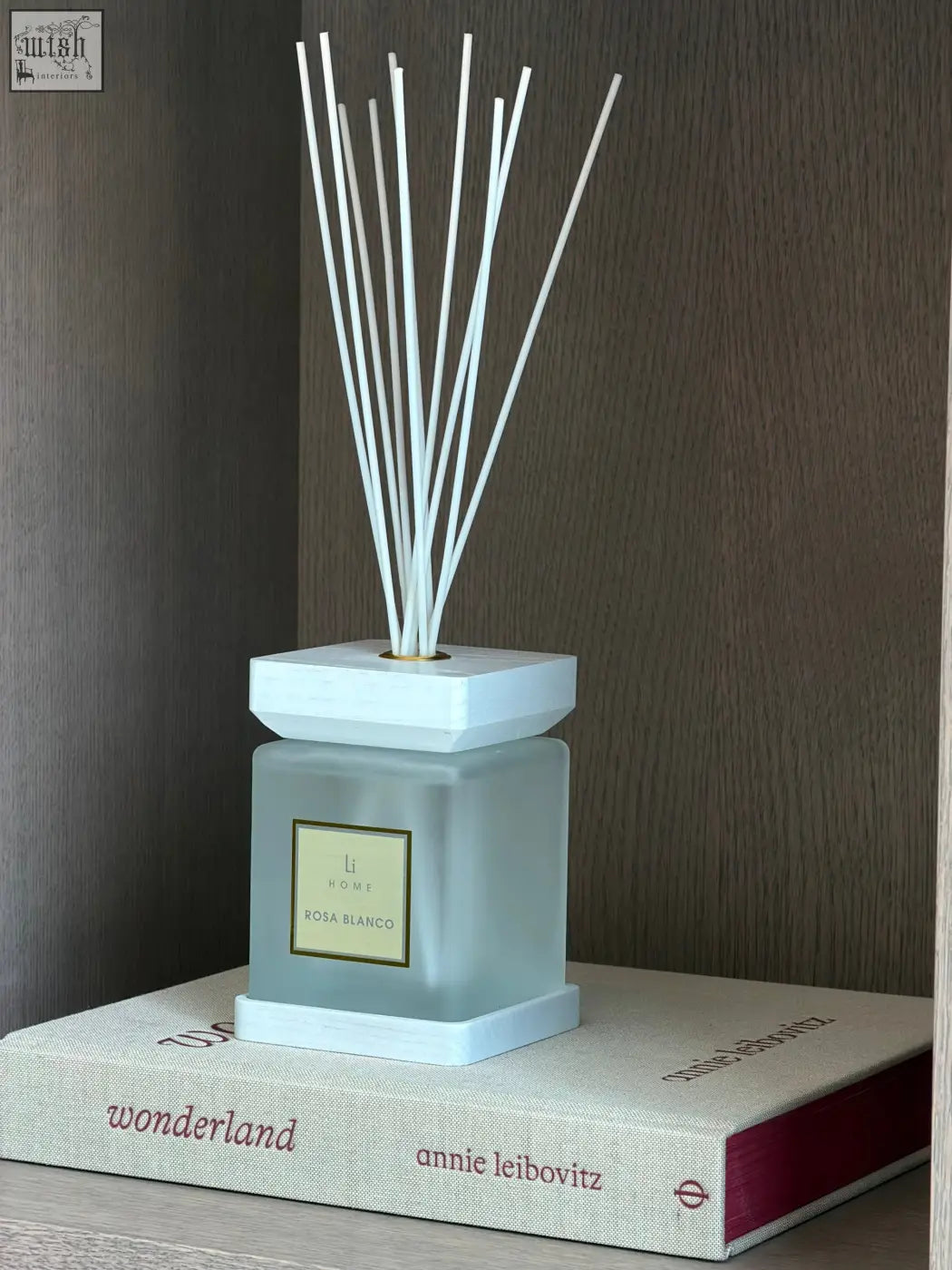 A sleek frosted glass luxury square diffuser with white geometric base and white rose rosa blanco scent reeds