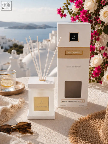 White ceramic luxury square diffuser with gold accents and rosa blanco label featuring slender white reeds and white rose scent